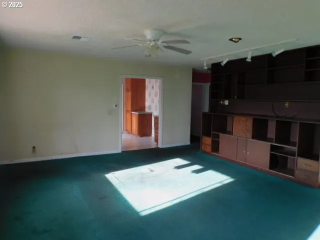 a view of an empty room with a kitchen