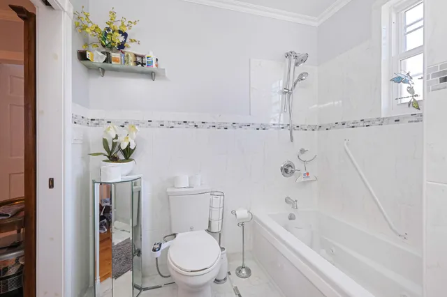 a white toilet sitting next to a bath tub