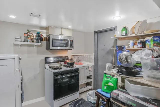a kitchen with a stove and a wooden floor