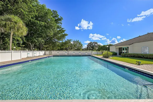 a view of a lake with a yard and large trees