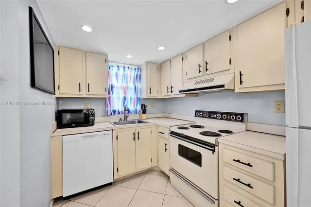 a kitchen with granite countertop white cabinets and white appliances