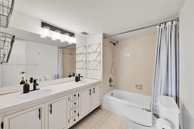 a bathroom with a double vanity sink a mirror a bathtub and a shower
