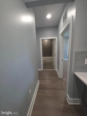 a view of hallway with stairs and wooden floor