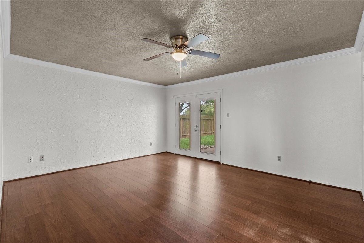 430 Redway Lane Houston, TX 77598 - Photo 11 of 43 a view of an empty room with wooden floor and a ceiling fan
