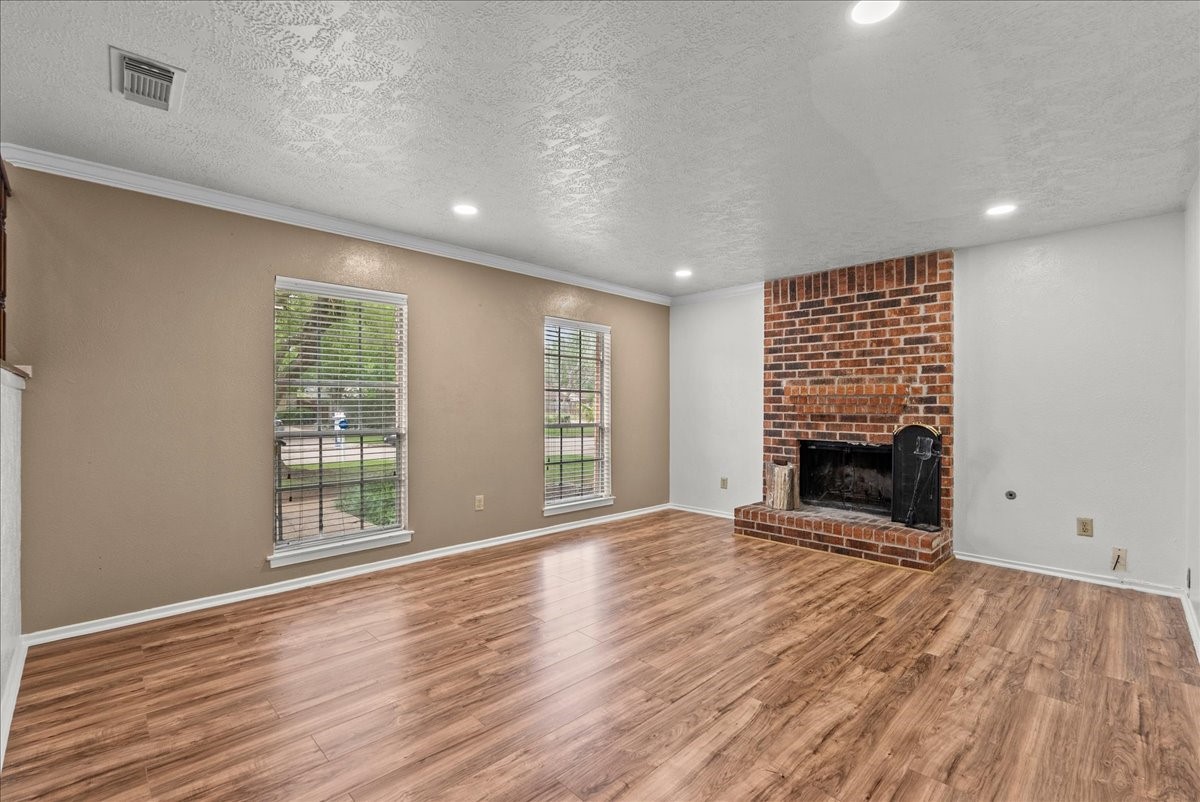 430 Redway Lane Houston, TX 77598 - Photo 9 of 43 wooden floor in an empty room with a fireplace