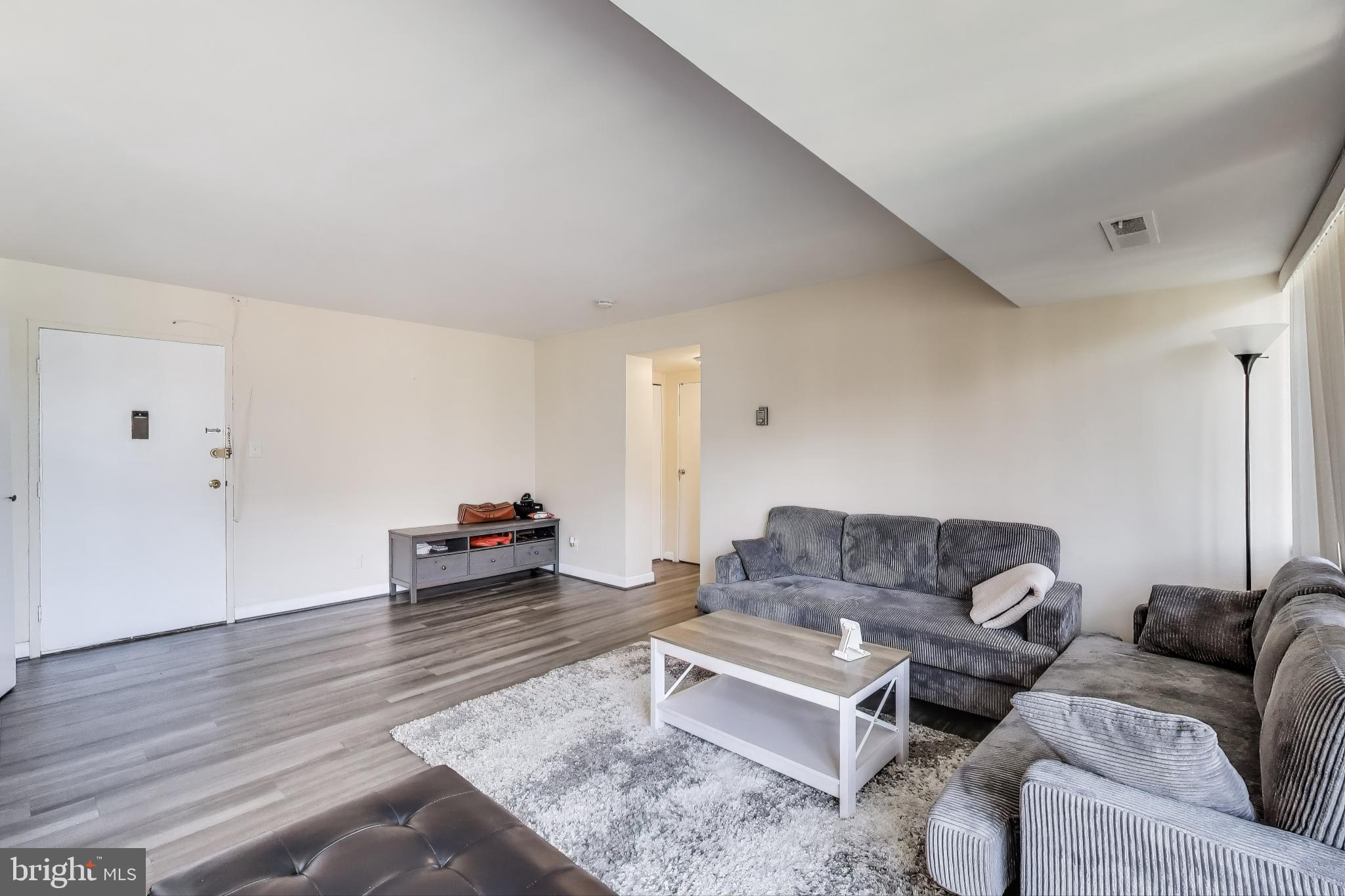 5851 Quantrell Avenue, Unit 407 Alexandria, VA 22312 - Photo 7 of 27 a living room with furniture and a wooden floor