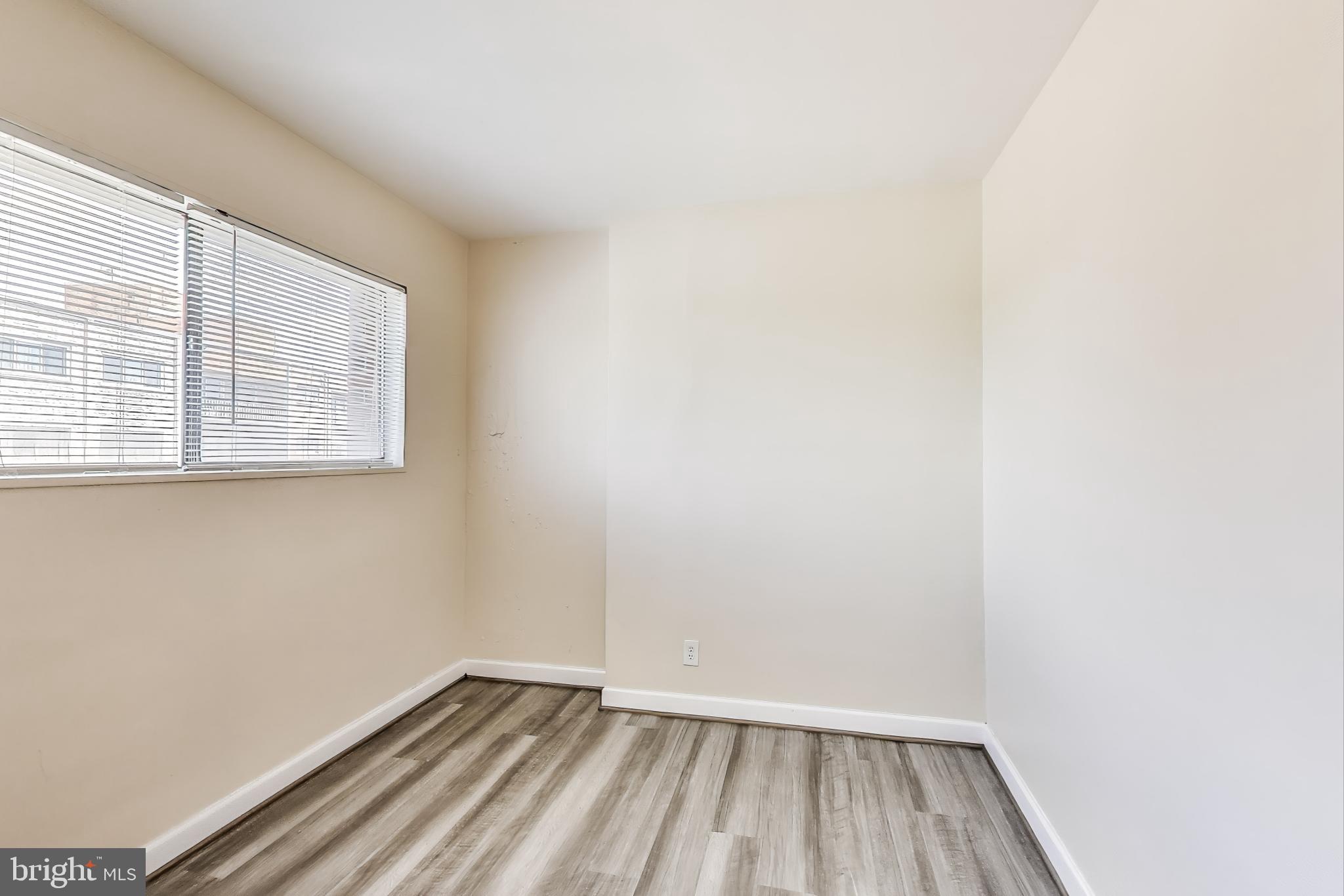 5851 Quantrell Avenue, Unit 407 Alexandria, VA 22312 - Photo 8 of 27 a view of an empty room with wooden floor and a window