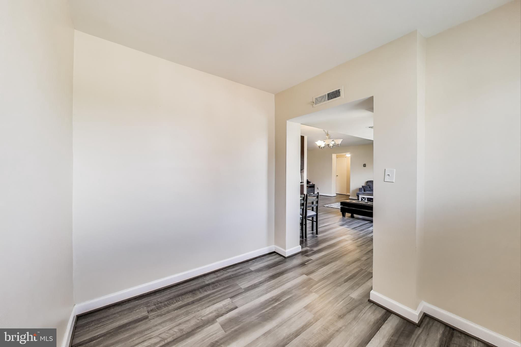 5851 Quantrell Avenue, Unit 407 Alexandria, VA 22312 - Photo 9 of 27 a view of a room with wooden floor furniture and a bathroom