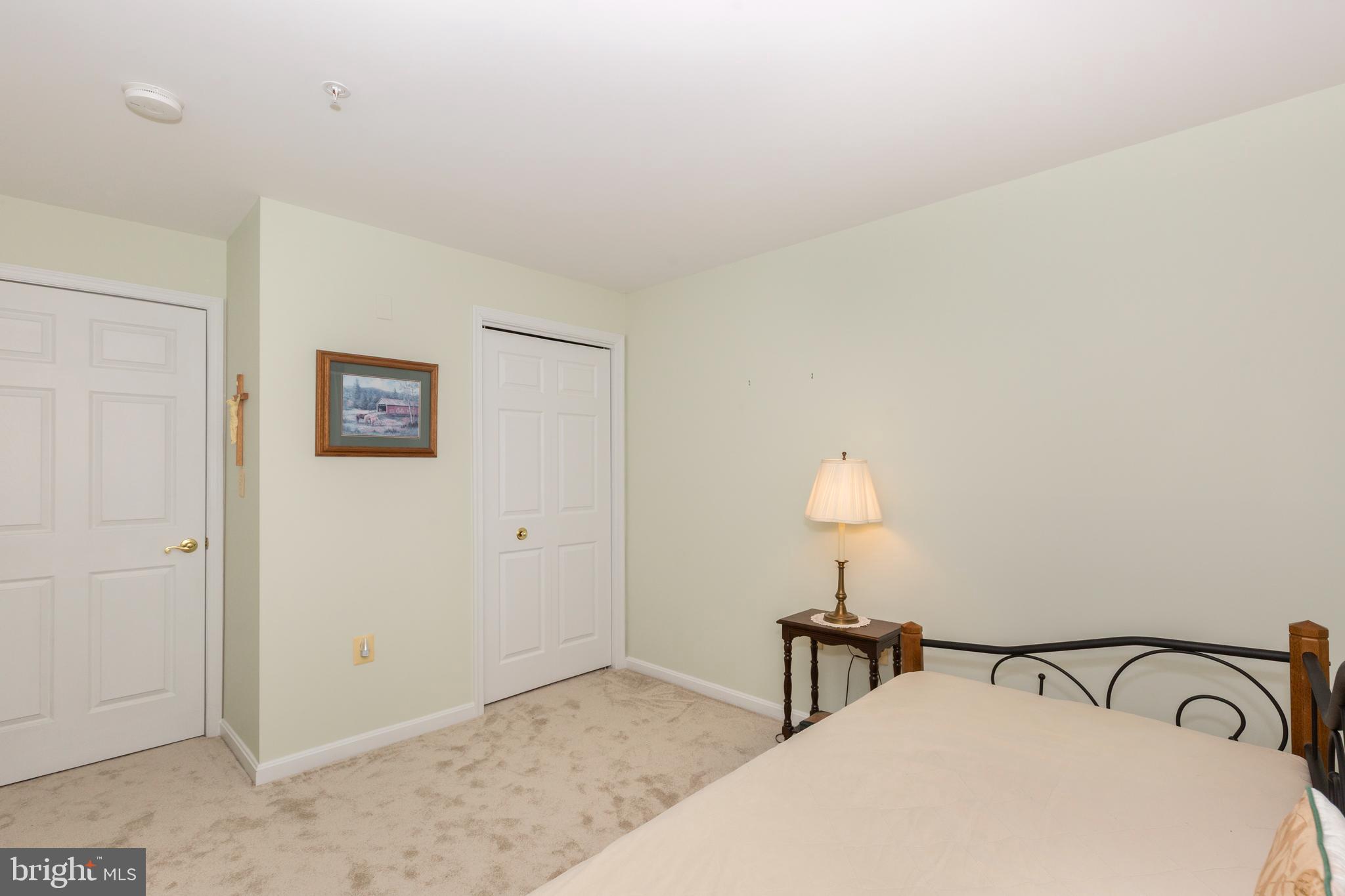 3850 Normandy Drive, Unit 2B Hampstead, MD 21074 - Photo 19 of 26 a bedroom with a bed and a lamp