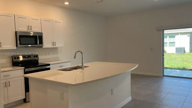 a kitchen with a sink a microwave and cabinets
