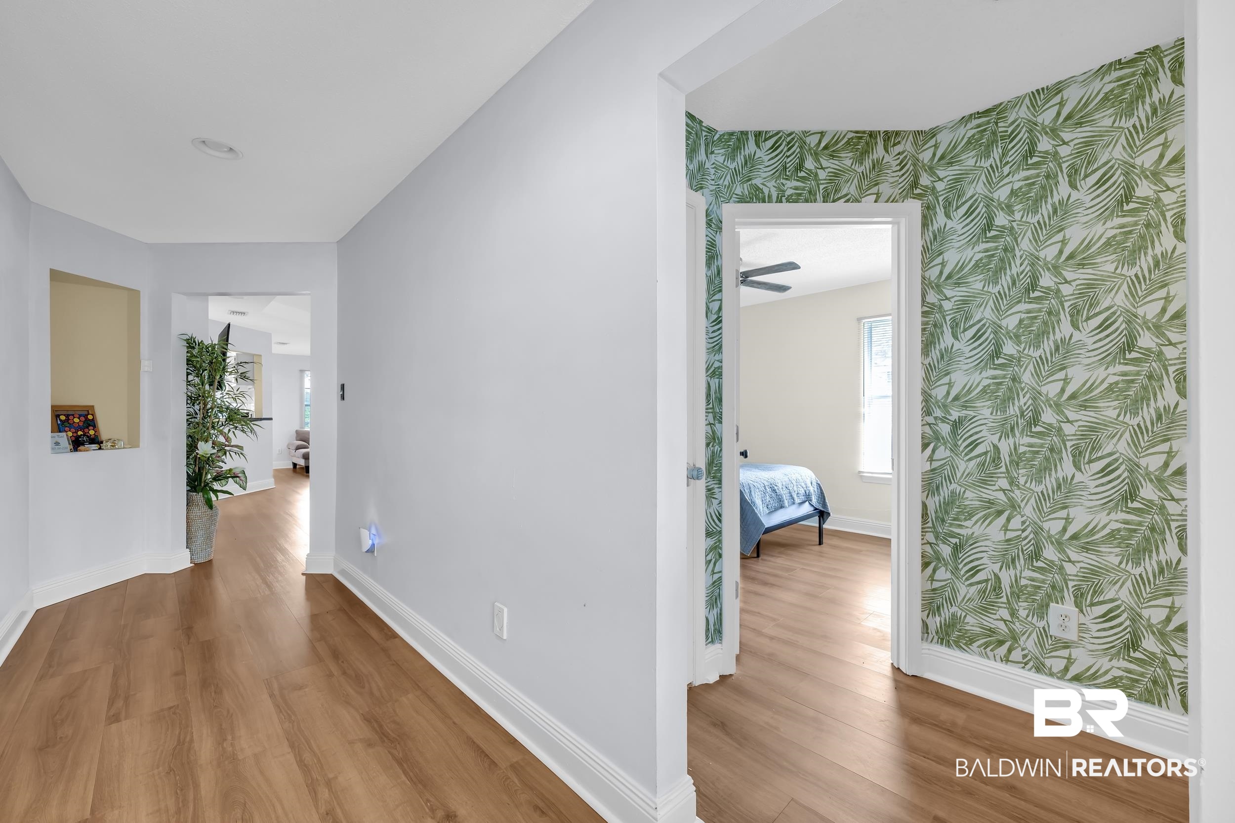 509 Loblolly Court Foley, AL 36535 - Photo 2 of 26 Hallway featuring wood-finish flooring, light grey painted walls, and decorative botanical wallpaper