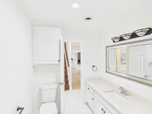 a bathroom with a sink a toilet a mirror and shower