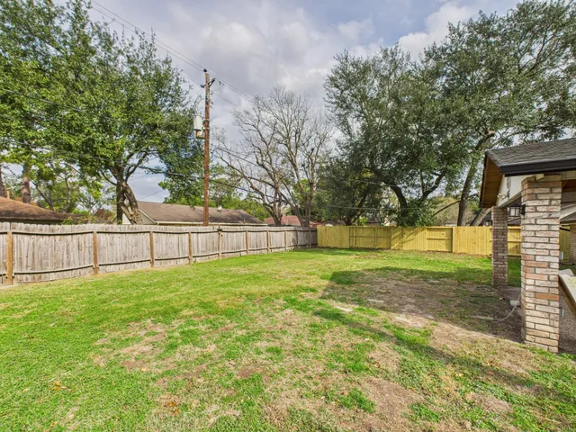 a view of a house with backyard and a tree