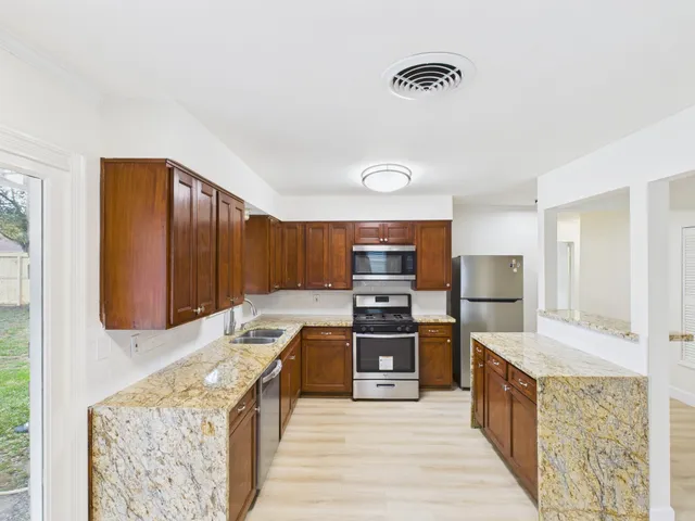 a kitchen with stainless steel appliances granite countertop a stove top oven a sink and dishwasher