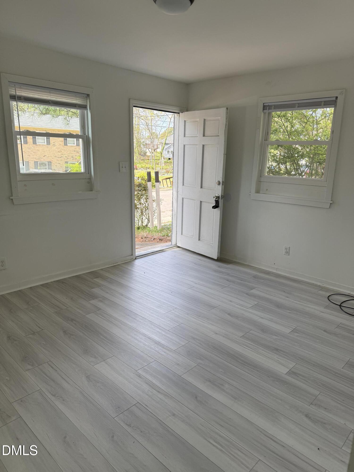 1015 Rosedale Avenue Durham, NC 27707 - Photo 2 of 15 a view of an empty room with wooden floor and a window