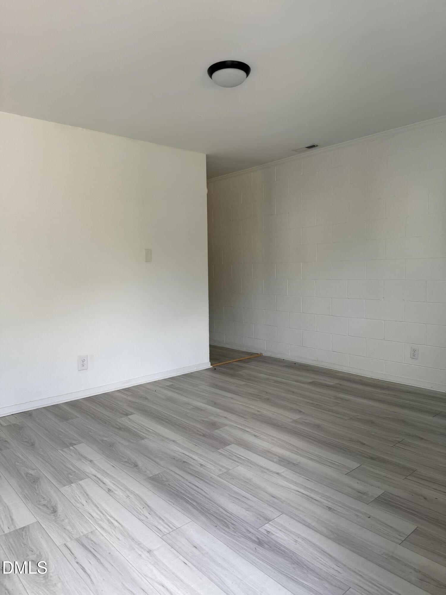 1015 Rosedale Avenue Durham, NC 27707 - Photo 3 of 15 a view of an empty room with wooden floor and a window