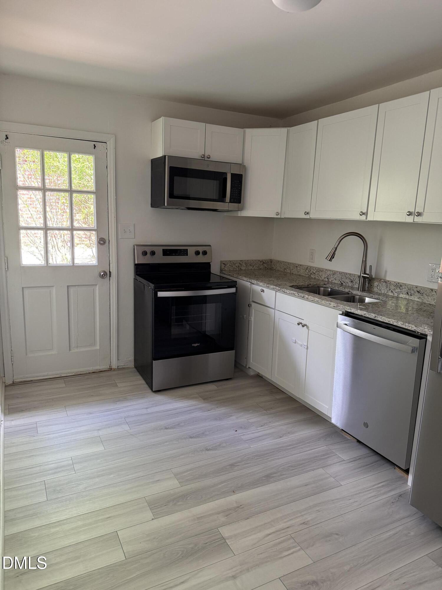 1015 Rosedale Avenue Durham, NC 27707 - Photo 5 of 15 a kitchen with stainless steel appliances granite countertop a stove a sink and a microwave