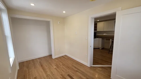 a view of a hallway with wooden floor and closet