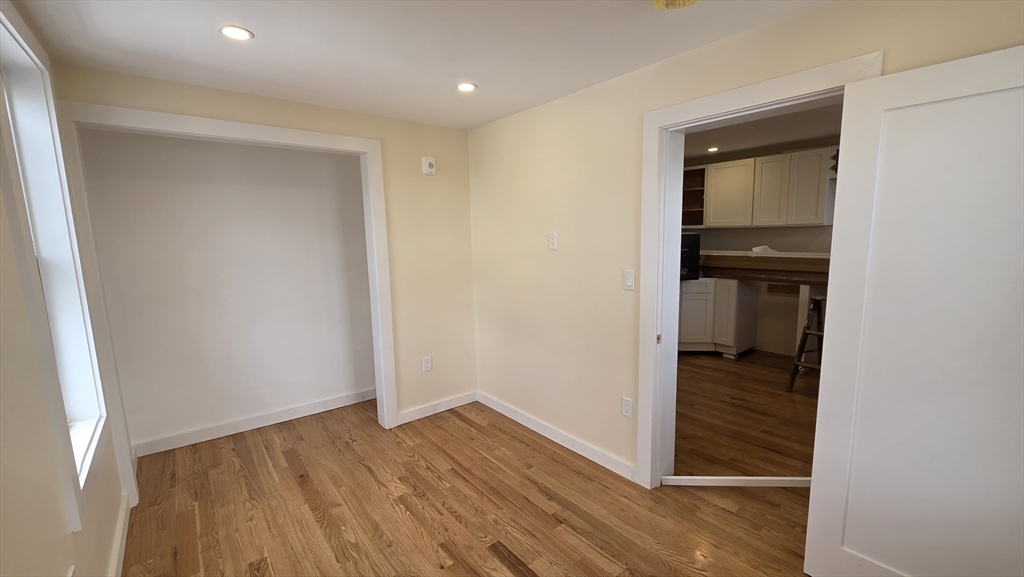 a view of a hallway with wooden floor and closet