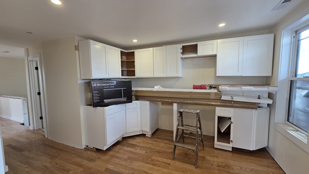 125 Central Avenue, Unit 3 Chelsea, MA 02150 - Photo 11 of 13 a kitchen with a sink cabinets and wooden floor
