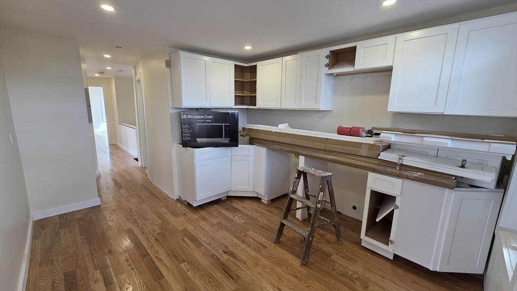 125 Central Avenue, Unit 3 Chelsea, MA 02150 - Photo 8 of 13 a kitchen with stainless steel appliances a stove a sink cabinets and wooden floor