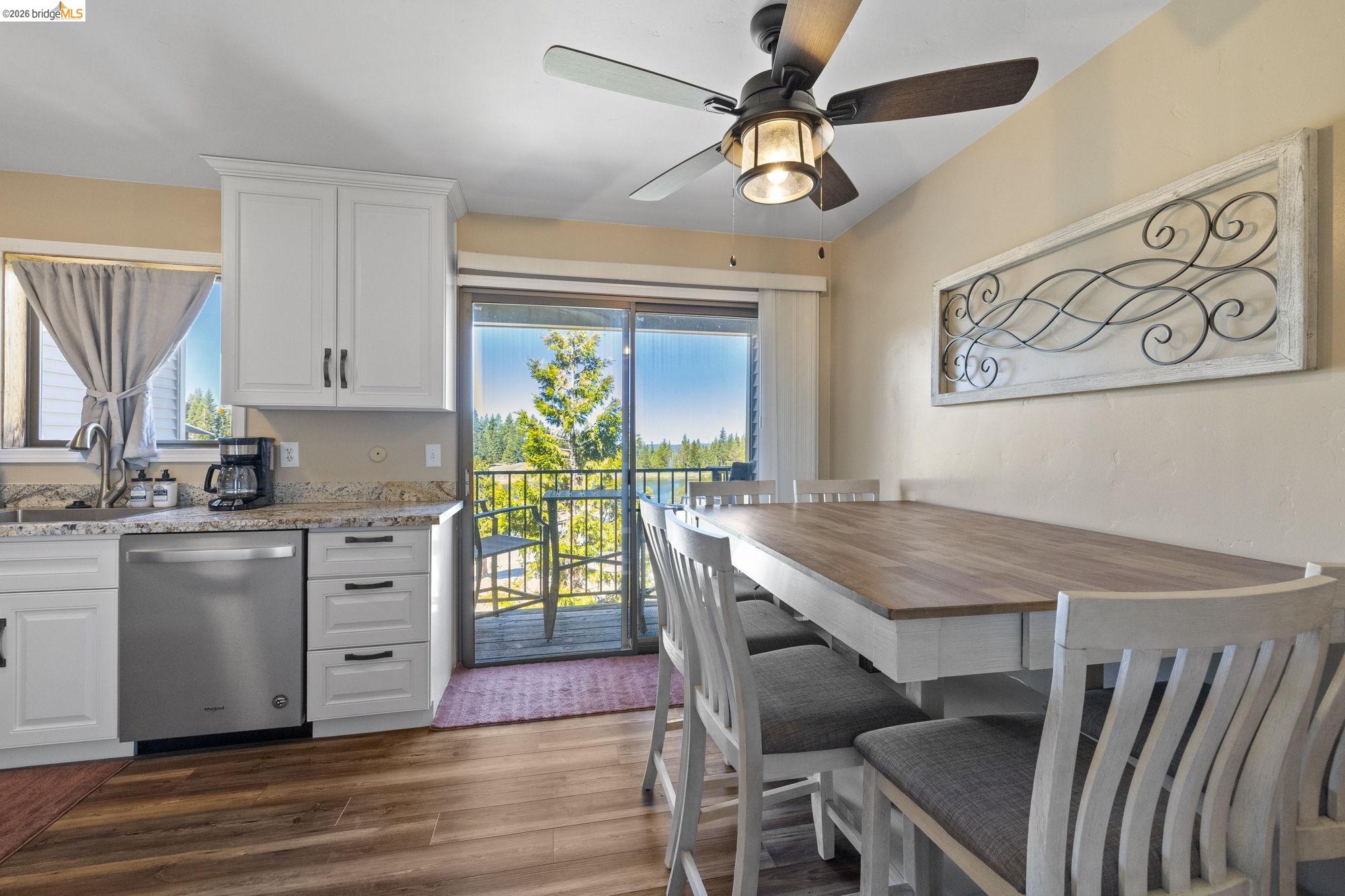 a kitchen with cabinets wooden floor and a dining table