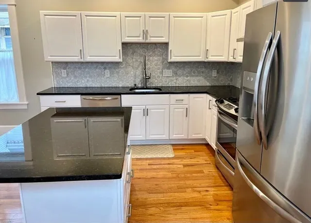a kitchen with granite countertop a refrigerator and a stove