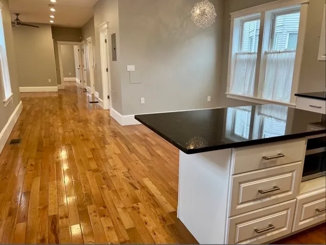 a view of kitchen with granite countertop cabinets and refrigerator