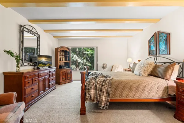 a spacious bedroom with a large bed and a wooden floor