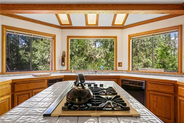 a kitchen with large windows a sink and appliances