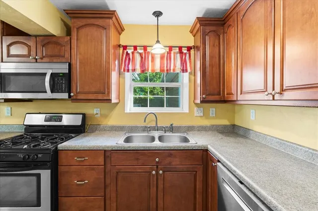 a kitchen with stainless steel appliances granite countertop a sink a stove and a microwave