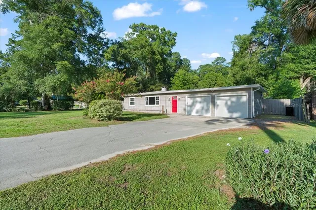 a view of a house with backyard and a tree