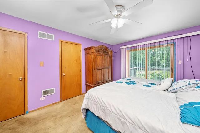 a bedroom with a bed and a large window