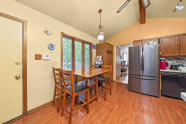 a kitchen with stainless steel appliances granite countertop a refrigerator a microwave oven a sink dishwasher and wooden floor