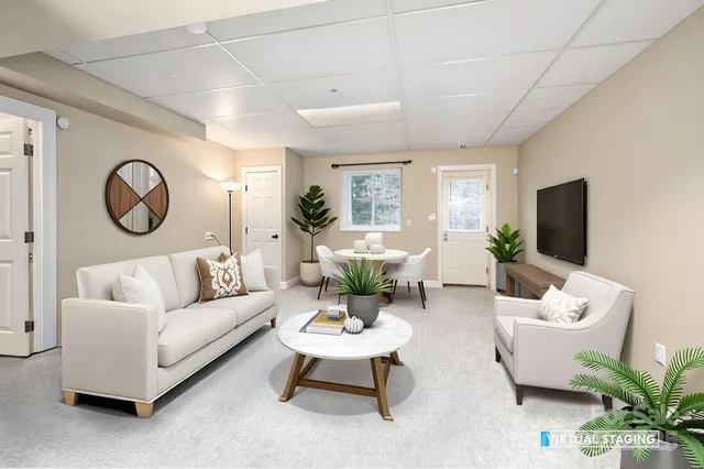 a living room with furniture a large window and a potted plant