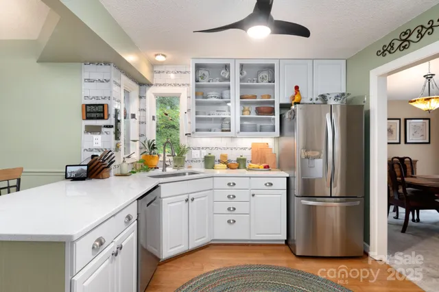 a kitchen with stainless steel appliances a refrigerator sink and cabinets