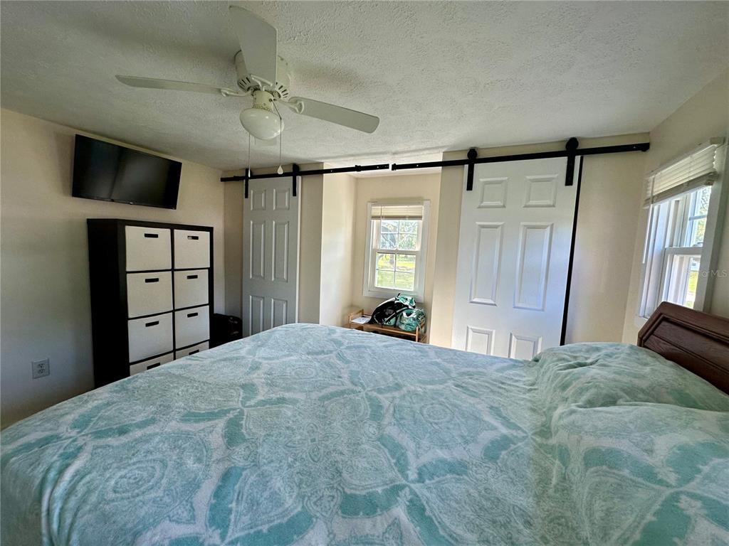 55045 6th Street Astor, FL 32102 - Photo 11 of 38 a large bedroom with a bed and a flat screen tv