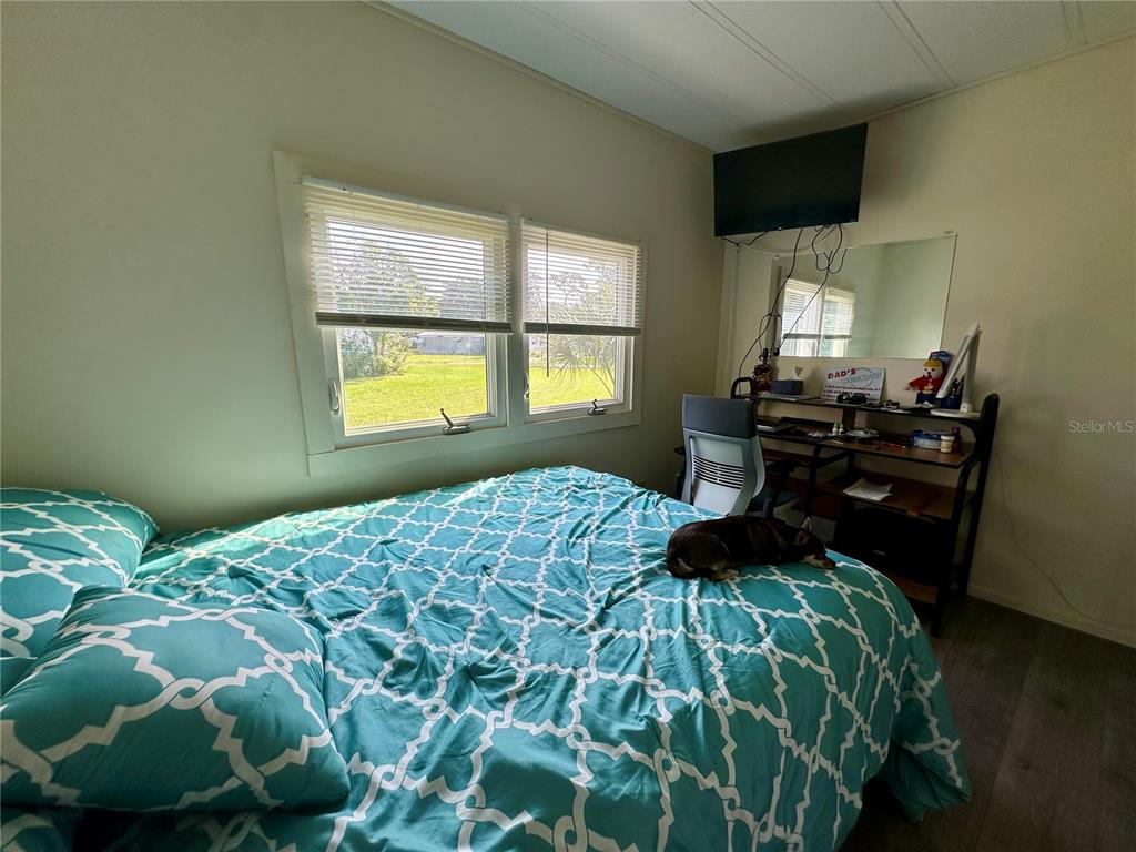 55045 6th Street Astor, FL 32102 - Photo 13 of 38 a bedroom with a bed window and wooden floor