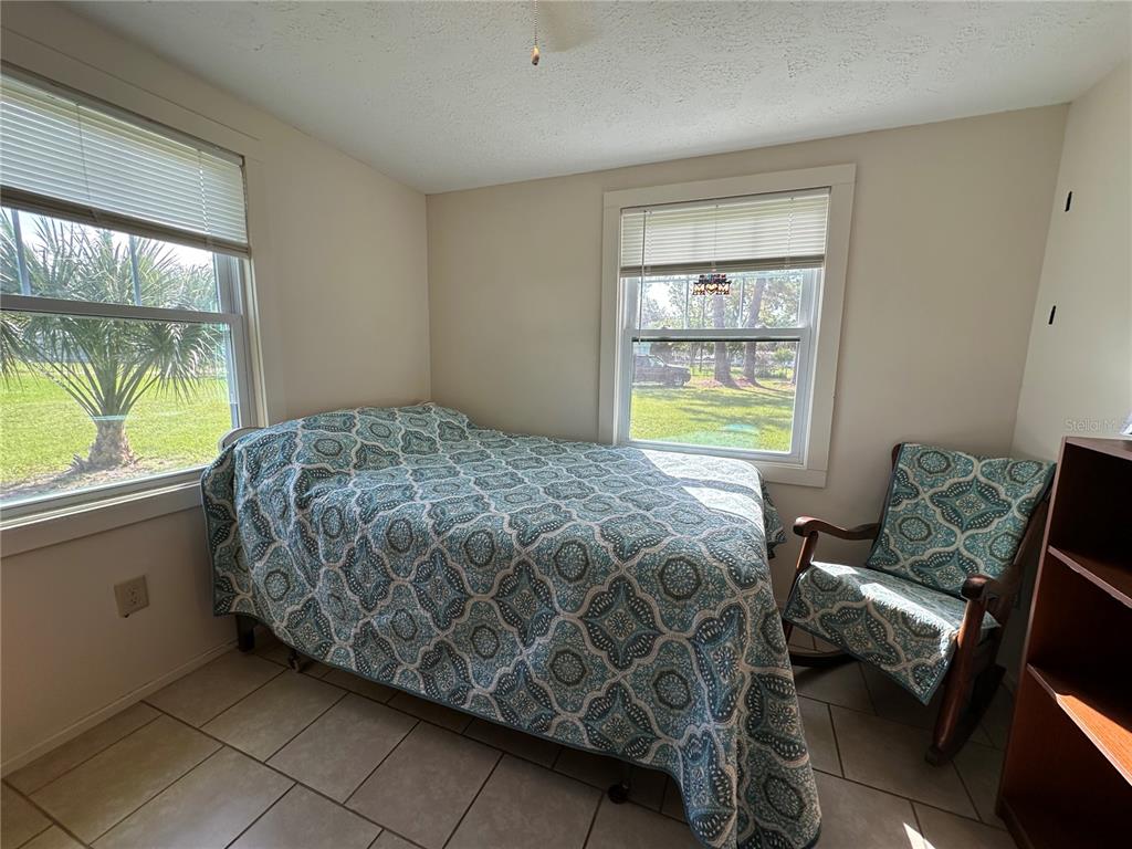 55045 6th Street Astor, FL 32102 - Photo 15 of 38 a bedroom with a bed and a window