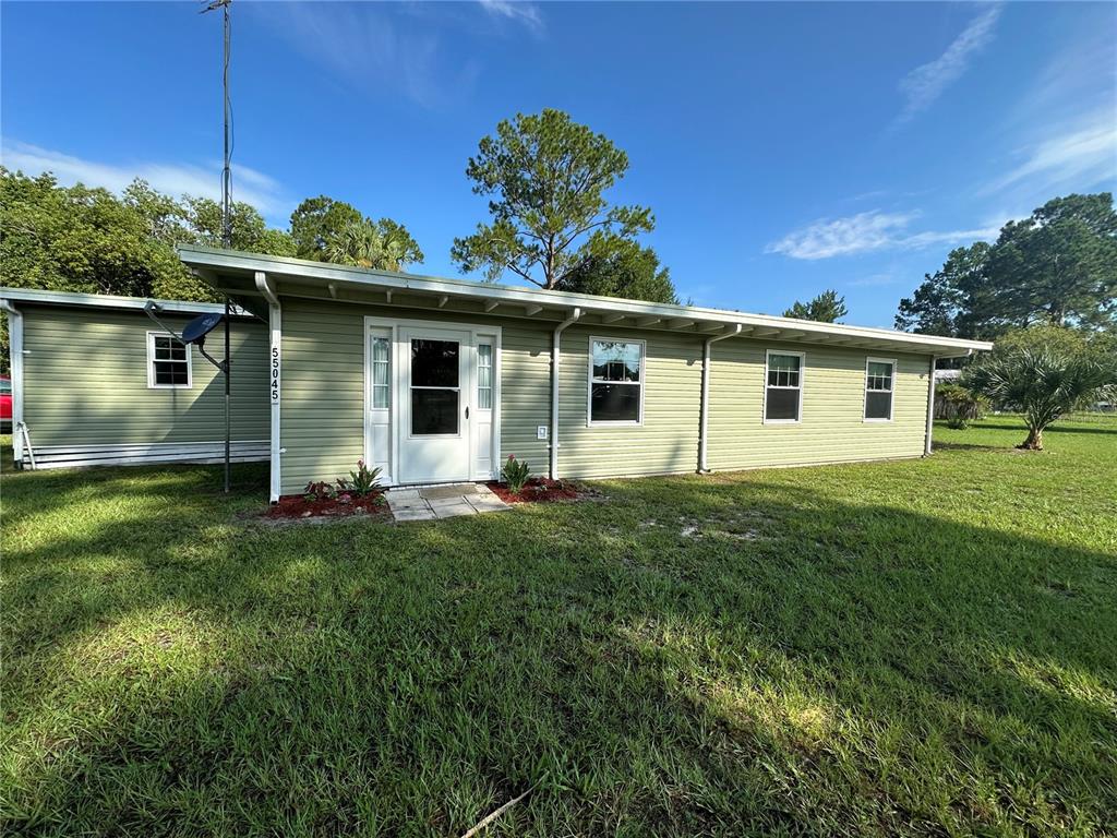 55045 6th Street Astor, FL 32102 - Photo 2 of 38 a front view of house with a garden