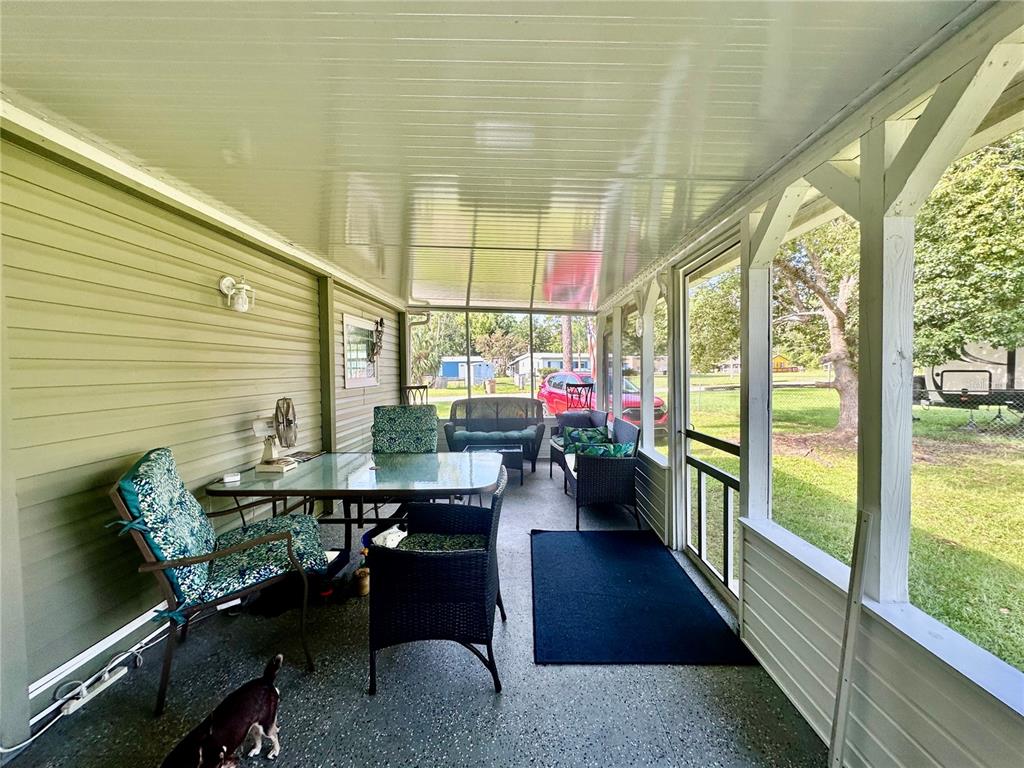55045 6th Street Astor, FL 32102 - Photo 26 of 38 a dining room with furniture and a floor to ceiling window