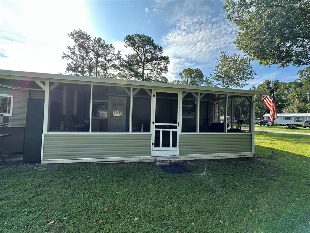 55045 6th Street Astor, FL 32102 - Photo 3 of 38 a view of a house with a yard and a large tree