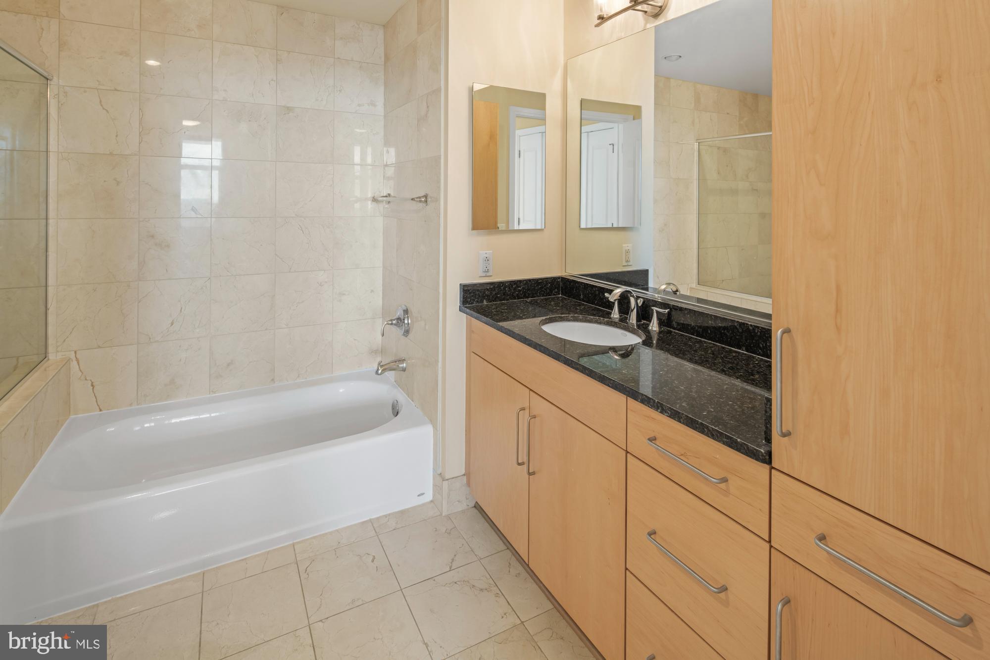 8220 Crestwood Heights Drive, Unit 1215 McLean, VA 22102 - Photo 17 of 59 a bathroom with a granite countertop sink a toilet a mirror and bathtub
