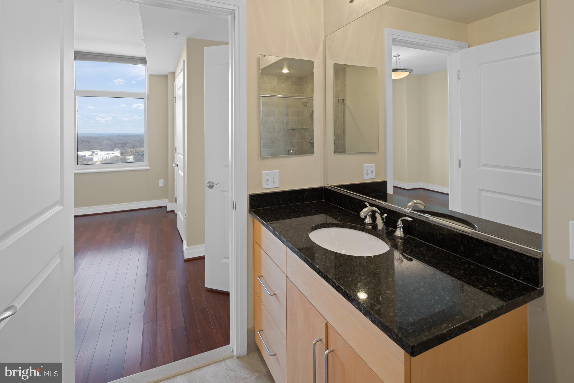 8220 Crestwood Heights Drive, Unit 1215 McLean, VA 22102 - Photo 29 of 59 a bathroom with a granite countertop sink a mirror and a shower