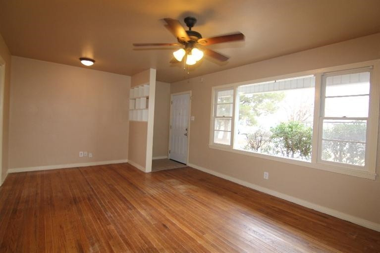 4407 37th Street Lubbock, TX 79414 - Photo 4 of 10 a view of an empty room with wooden floor and a window