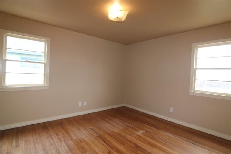 4407 37th Street Lubbock, TX 79414 - Photo 6 of 10 an empty room with wooden floor and windows
