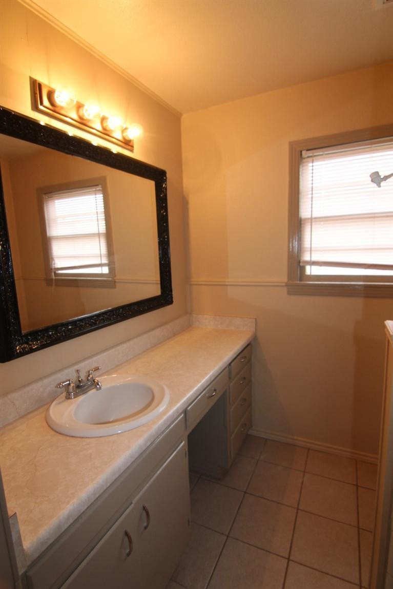 4407 37th Street Lubbock, TX 79414 - Photo 8 of 10 a bathroom with a sink and a mirror