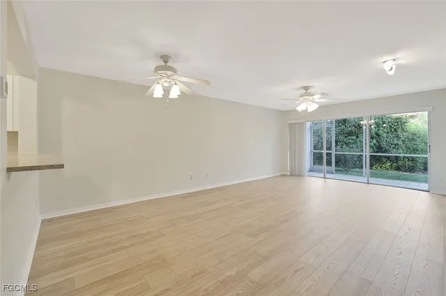 a view of a room with wooden floor and a ceiling fan
