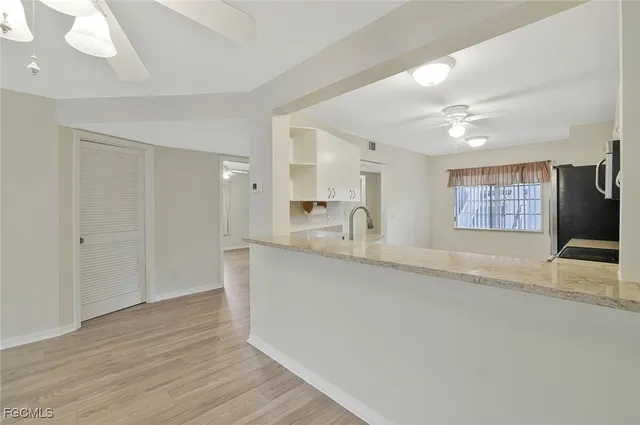 a view of large kitchen with a sink and dishwasher with wooden floor