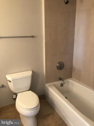 a white toilet sitting next to a bath tub